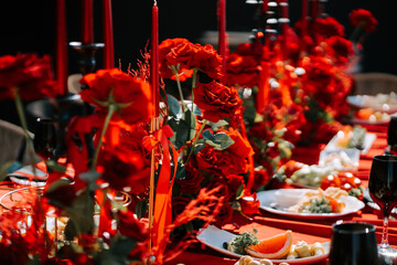 Elegant red-themed dinner setting with flowers and candles for a special occasion