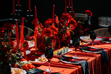Elegant red-themed dinner setup with flowers and candles for a special occasion