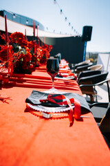 Elegant table setting with red decorations for outdoor gathering in bright sunlight