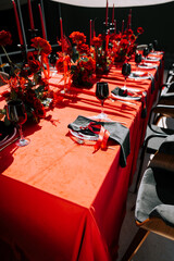 Elegant red table setting with flowers and candles for a sophisticated gathering