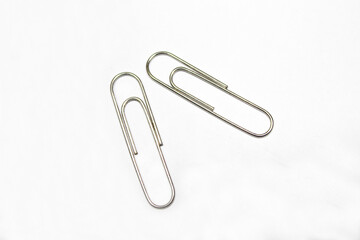 Silver paper clips isolated on white background. Paper clips background texture.