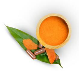 Turmeric powder in wooden bowl and turmeric root  on leave. Top view with copy space for your text....