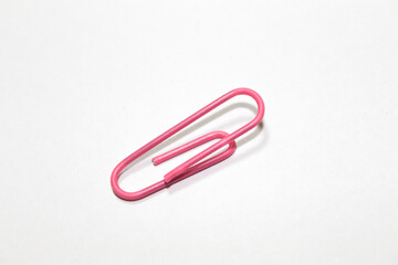 Pink paper clips isolated on white background. Paper clips background texture.