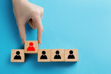 Dismissal. Woman taking cube with red human icon among others with black ones on light blue...