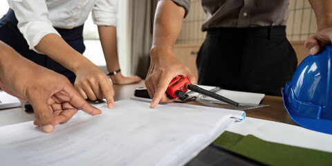 Sustainability Collaboration Team Analyzing Project Blueprints at Eco-Friendly Project Plan