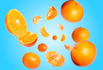 Juicy tangerines swirling in air against light blue gradient background