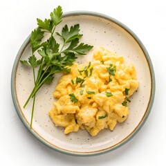 Overhead view of scrambled eggs with parsley on a plate with white solid backround