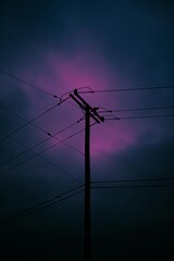 Electricity Post under Cloudy Sky: A solitary electricity post pierces the sky, its dark silhouette contrasting against the moody, cloudy background.