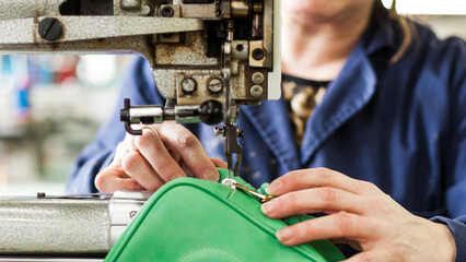 Leather sewing process with industrial machine in workshop
