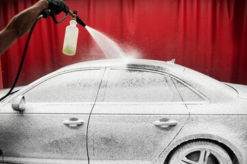 Car Foaming Stage. High-pressure snow foam application ensures deep cleaning and softens grime on car surface. Car gets covered in thick snow foam during initial washing phase for deep dirt removal.