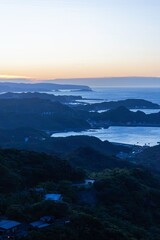 Fototapeta premium Coastal landscape at dusk with mountains and sea.