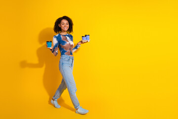 Stylish young woman holding coffee and gift against a yellow backdrop embodying modern style and vibrant leisure