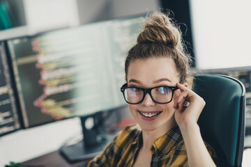 Young female programmer working on coding project at home office with multiple screens, showcasing...