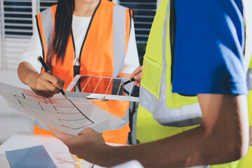 Closeup of team of industrial engineers meeting analyze machinery blueprints consult project on...