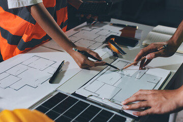 Closeup of team of industrial engineers meeting analyze machinery blueprints consult project on...