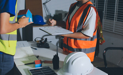 Closeup of team of industrial engineers meeting analyze machinery blueprints consult project on...