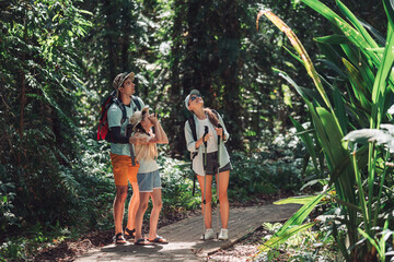 Hiking People on Family Vacation Bird Watching Together in Forest Trail With Parents and Daughter Enjoying Nature