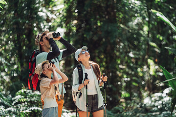 Hiking People on Family Vacation Bird Watching Together in Forest Trail With Parents and Daughter Enjoying Nature