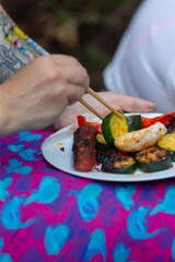 A person is enjoying a delicious plate of food while skillfully using chopsticks to eat their meal in a delightful manner