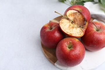 Spoiled apple and good ones on white table, closeup. Space for text