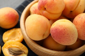 Fresh ripe apricots in bowl on table, closeup