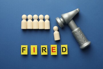 Dismissal. Word Fired, hammer and human figures on blue background, flat lay