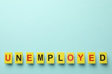 Word Unemployed on light blue background, top view. Space for text