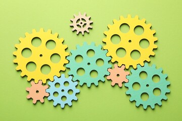 Unemployment. Gearwheels on green background, flat lay