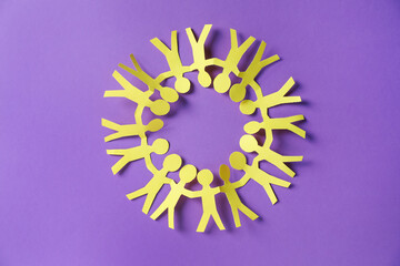 Paper figures of people holding hands on purple background, top view
