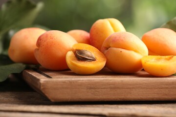 Fresh ripe apricots on wooden table outdoors, closeup