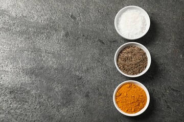 Different aromatic spices on grey table, flat lay. Space for text