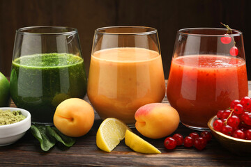 Superfood. Tasty smoothies in glasses and ingredients on wooden table, closeup