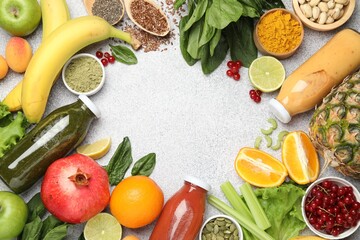 Superfood. Tasty smoothies in glass bottles and ingredients on light grey table, flat lay. Space for text