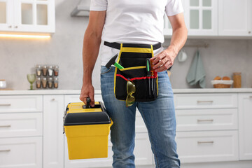 Professional repairman with tool box indoors, closeup