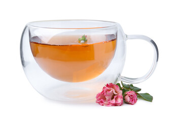Aromatic tea in glass cup, roses and green leaves isolated on white