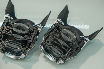 Two photo lenses, cut in half, lie next to each other on the table with cut side up.