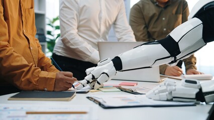 A futuristic scene shows a human interacting with a robotic arm in a modern office, exemplifying...