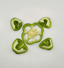 Fresh cut capsicum or, green bell peppers on white background. Whole and cut green bell peppers on...