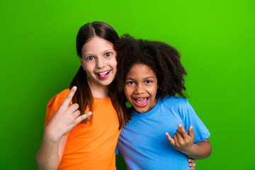 Two young friends making funny poses and enjoying a joyful moment with vibrant green background