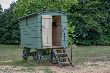 rustic green shepherds hut with trees in the background