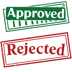 Fototapeta premium Green approved stamp lies above a red rejected stamp showing contrasting decisions