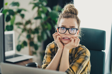 Worried professional woman feeling nervous in workplace with computer and casual attire in modern...