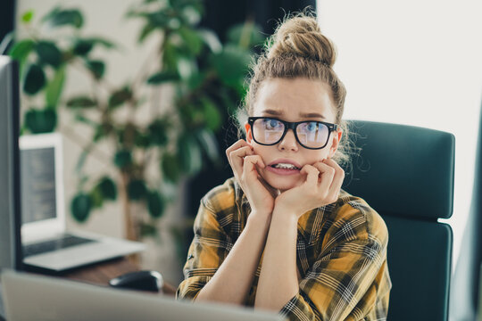 Worried professional woman feeling nervous in workplace with computer and casual attire in modern office environment
