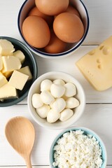 Different dairy products and eggs on white wooden table, flat lay