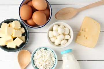 Different dairy products and eggs on white wooden table, flat lay