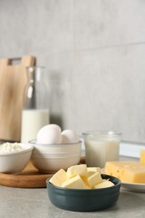 Different dairy products and eggs on gray textured table in kitchen