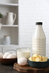 Different dairy products and eggs on gray textured table in kitchen