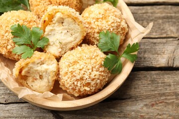Delicious fried croquette balls with parsley on wooden table, above view