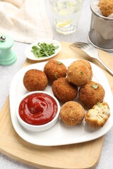 Delicious fried croquette balls with parsley and ketchup on grey textured table, closeup