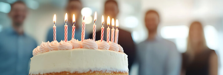 Celebratory cake with lit candles at an office party with colleagues, symbolizing a birthday celebration or a work anniversary.